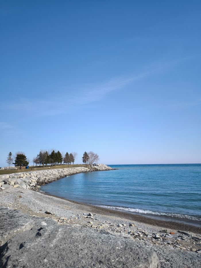 Tranquil beach scenery in Toronto with blue skies and calm waters.