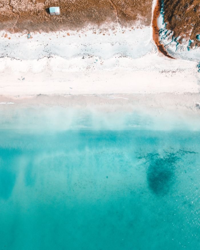 A serene aerial shot of a pristine beach with turquoise waters, ideal for summer vacations.